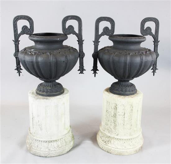 A pair of cast iron two handled urns, W. 1ft 11in. height overall 3ft 9in.